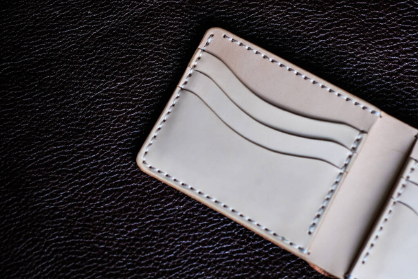 Pravá kožená peněženka ručně vyrobená na koženém pozadí řemeslný objekt - Fotografie, Obrázek