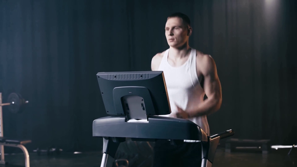 sportive man running on treadmill in gym  - Záběry, video