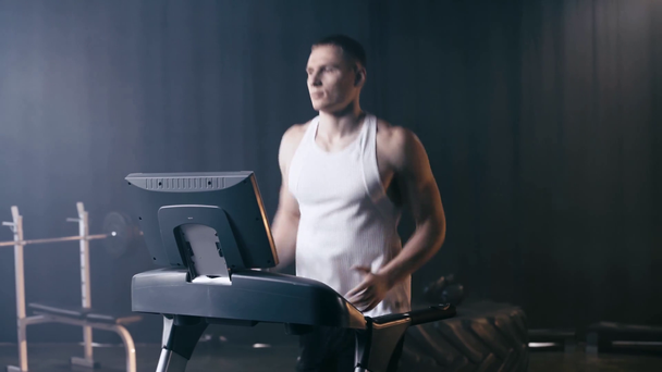 Sportowiec biegający na bieżni na siłowni  - Materiał filmowy, wideo