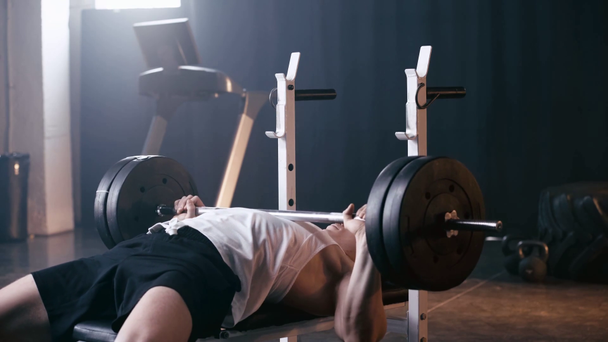 lekkoatletyczny sportowiec podnoszenie ciężkich sztangi w siłowni  - Materiał filmowy, wideo