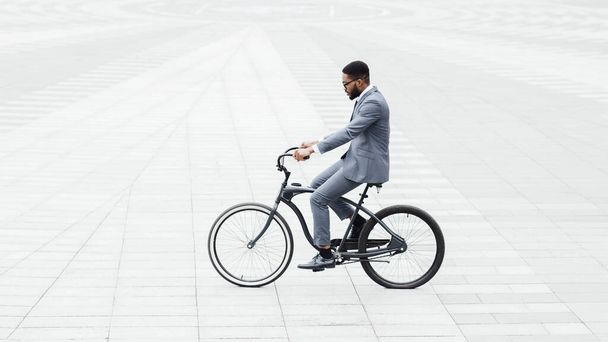 Bonito empresário afro andando de bicicleta para o trabalho, isolado
 - Foto, Imagem