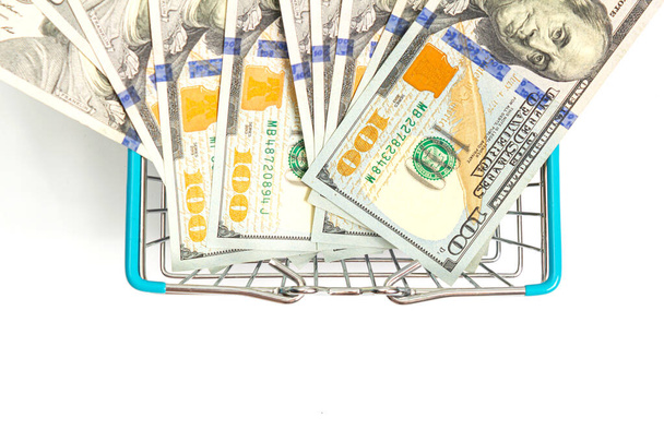 una cesta con inserciones azules se inserta en los billetes de cien dólares envueltos en un fondo blanco. aislar
 - Foto, imagen