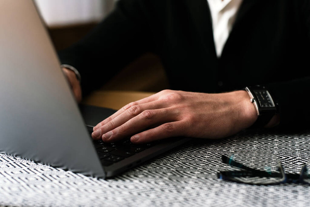 діловий чоловік зайнятий використанням ноутбука на офісному столі, молодий студент, що друкує на комп'ютері, сидить за дерев'яним столом
. - Фото, зображення