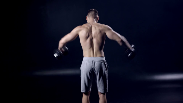Siyah dambıllarla egzersiz yapan bir adamın arka planı  - Video, Çekim