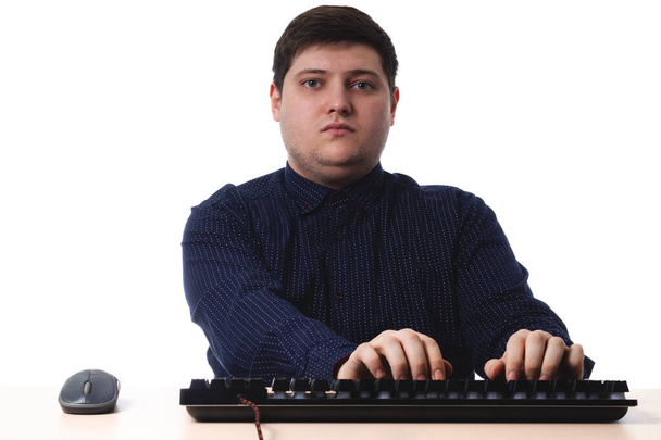 Klavye ofisinde koyu mavi gömlekli genç adam, beyaz arka planda iş. İzole et. Boşluğu kopyala - Fotoğraf, Görsel