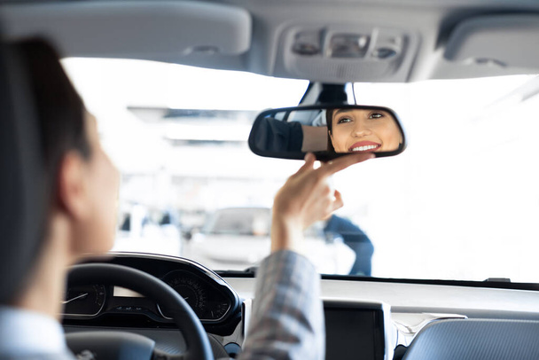 Menina verificando espelhos sentado no assento dos motoristas
 - Foto, Imagem