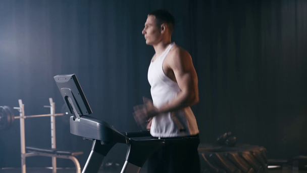 profile of handsome man running on treadmill in gym  - Footage, Video