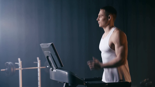 profil sportowca biegającego na bieżni na siłowni  - Materiał filmowy, wideo
