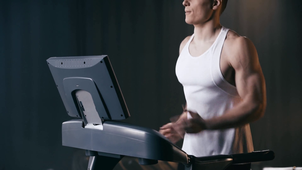 przycięty widok sportowca biegającego na bieżni w siłowni  - Materiał filmowy, wideo