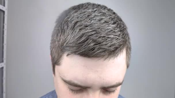  Egy férfi egy szépségszalonban lakkal van lefújva a hajára. A férfi hajápolás fogalma. - Felvétel, videó