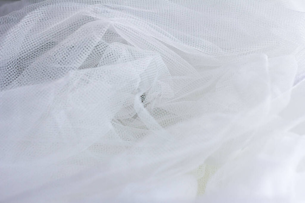 Tulle, fabric, white tulle. The texture of the fabric , the texture of tulle, soft white material.Draped tulle close -up. - Photo, Image