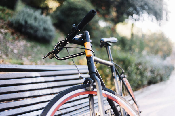 Bike leaning on a bench outside in a park - Foto, Bild