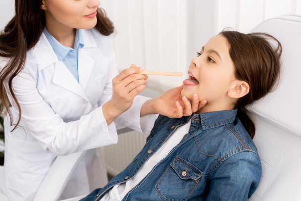 HNO-Arzt untersucht Kehle von Kind mit Zungendepressor - Foto, Bild