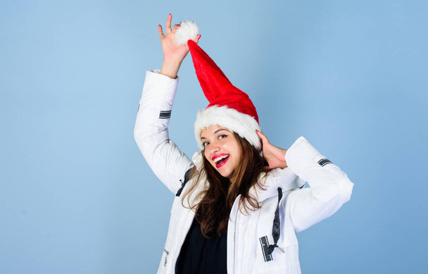 Santa girl. Girl wear white jacket and santa hat. Jacket has extra insulation to protect your body from sharp winter weather. White jacket. Waiting frosty christmas days. Emotional woman makeup face - Foto, Bild