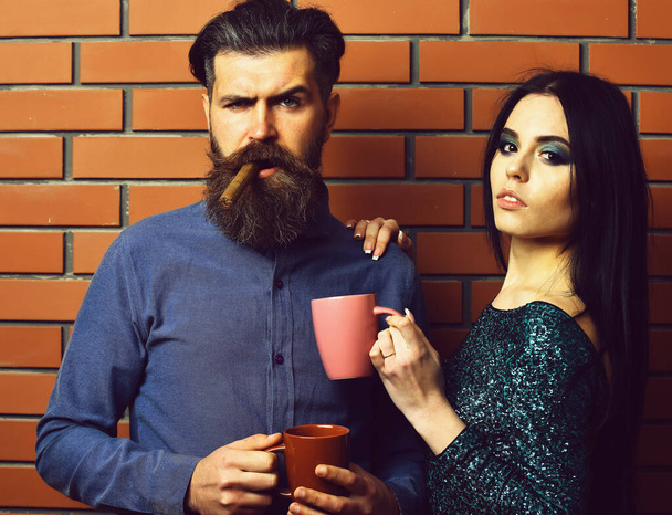 bearded man and pretty sexy woman with cigar, tea cups - Photo, Image