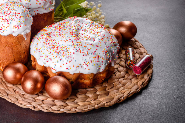 Пасхальные яйца золотые и бронзовые и пасхальный торт на темном фоне. Подготовка к празднику
 - Фото, изображение