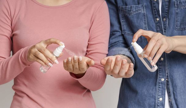 Imagem recortada de homem e mulher irreconhecíveis aplicando higienizadores de mãos
 - Foto, Imagem