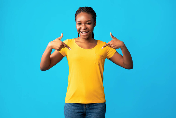 アフリカ系アメリカ人の女の子は青の背景に自分自身で指を指す - 写真・画像