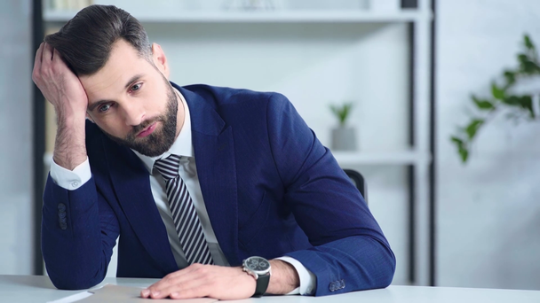Frustrierter Geschäftsmann im Anzug berührt Kopf im Büro  - Filmmaterial, Video