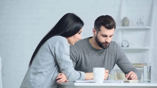 rozrušený muž a žena mluví blízko kalkulačka na stole  - Záběry, video