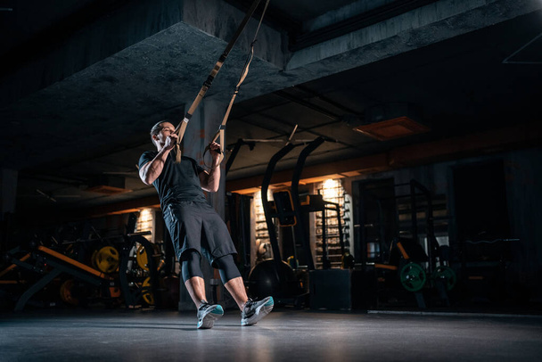 young man has crossfit workout with trx in modern gym - Photo, Image