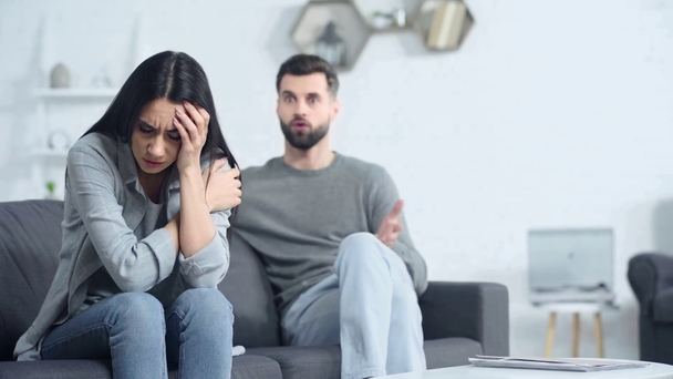 selective focus of sad woman sitting near displeased boyfriend  - Footage, Video