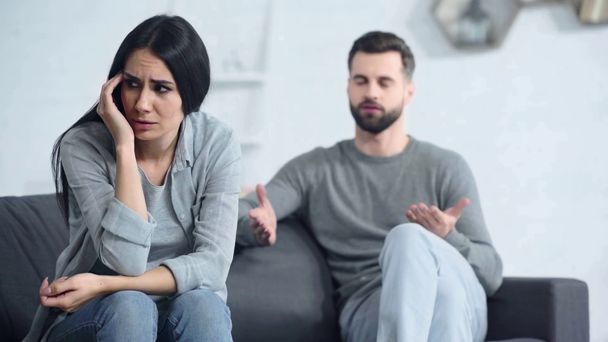 επιλεκτική εστίαση της αναστατωμένης γυναίκας κάθεται κοντά δυσαρεστημένος φίλος  - Πλάνα, βίντεο