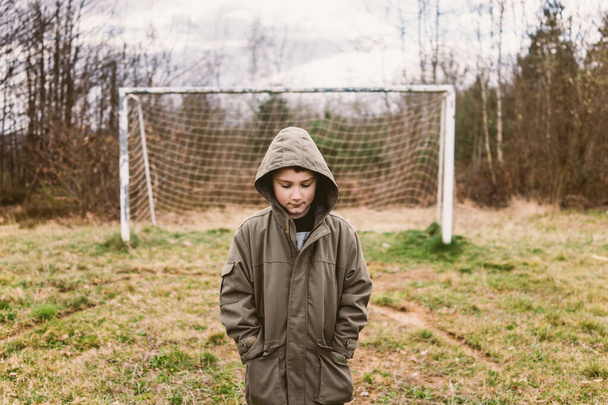 Chlapec stojící na opuštěném fotbalovém hřišti  - Fotografie, Obrázek