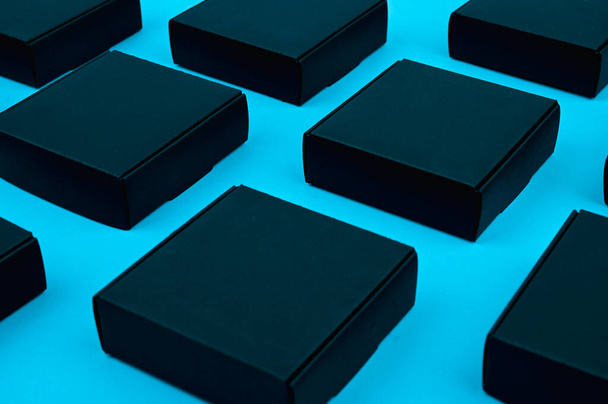 černé kostky proudí. černé krabice na modré. černé krabice na modrém pozadí na rovině ležely. Černý čtverec na modré - Fotografie, Obrázek