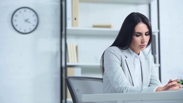 bouleversé femme d'affaires regardant loin tout en étant assis au bureau  - Séquence, vidéo