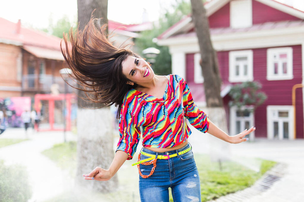 Koncepcja lata i radości - radosna młoda kobieta rzucająca włosami na zewnątrz, uśmiechająca się i czująca się radosna i wolna oraz bawiąca się w słoneczny dzień - Zdjęcie, obraz