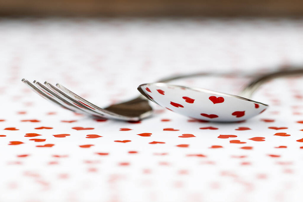Reflection of a tablecloth of hearts in the cutlery that is on a table - Fotografie, Obrázek