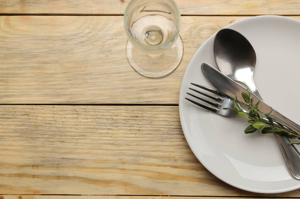 Apparecchiare. Piatto, forchetta di vetro e posate, cucchiaio e coltello su un tavolo di legno naturale. vista dall'alto
 - Foto, immagini