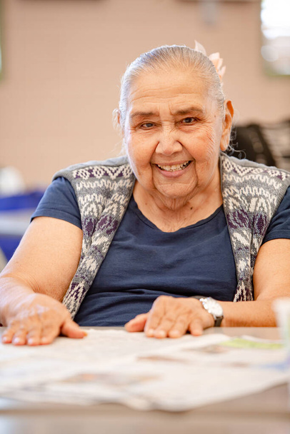 Cheerful Mexican woman in a senior activity center - Foto, afbeelding