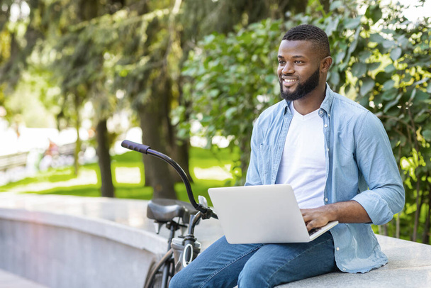 Knap Afrikaans Amerikaans ondernemer werken op laptop buiten - Foto, afbeelding