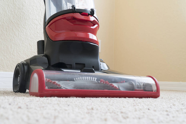 Vacumm cleaner is used to clean a carpet surface while doing houshold chores - Фото, зображення