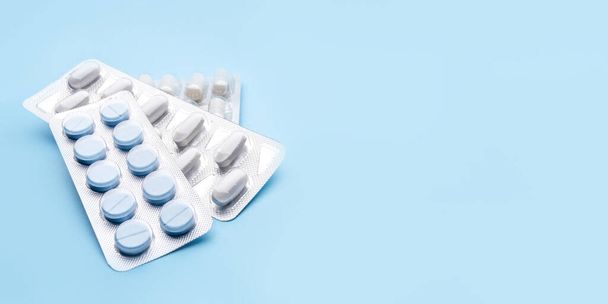 Pills in blister packs on blue background. - Φωτογραφία, εικόνα