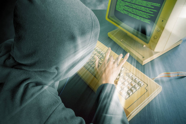 High angle of unknown hacker trying to hack system while typing on the keyboard  - Foto, Bild