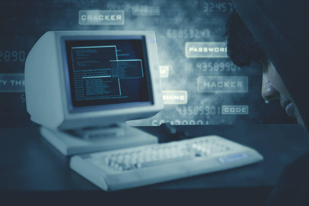Bild eines unbekannten Mannes vor Computer und Tastatur mit Binärcode auf dem Bildschirm  - Foto, Bild
