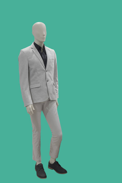 Maniquí masculino de cuerpo entero vestido con traje gris, aislado sobre fondo verde. No hay marcas u objetos de copyright
. - Foto, imagen