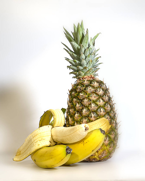 ananases e bananas isoladas sobre fundo branco. Empilhamento de foco em destaque
 - Foto, Imagem