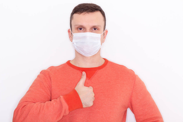 Portrait of a man on a white isolated background, face covered with a medical mask, banner for text. Health, awareness, and timeliness. Healthy lifestyle. No viruses. - Foto, immagini