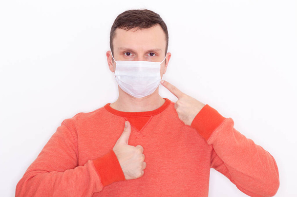 Portrait of a man on a white isolated background, face covered with a medical mask, banner for text. Health, awareness, and timeliness. Healthy lifestyle. No viruses. - Фото, изображение
