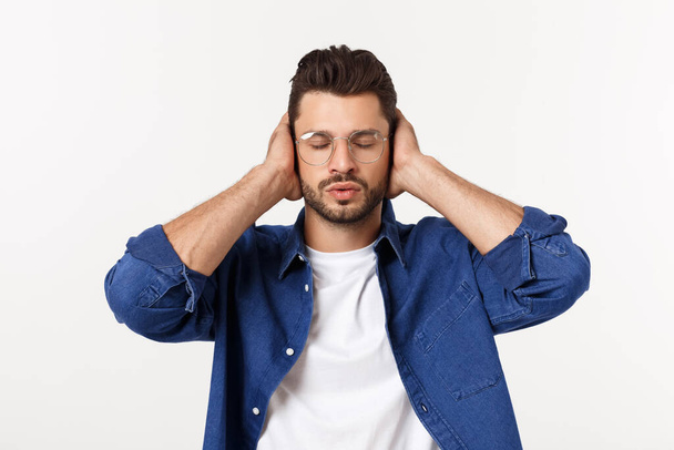 young man covering his ears, closing his eyes, isolated on white background. Hear no evil concept. Emotions facial expressions and communication sign - Foto, immagini