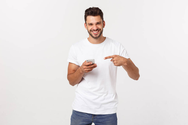 Щасливий випадковий чоловік грає на смартфоні на сірому фоні
 - Фото, зображення
