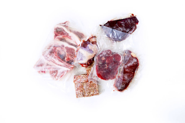 Top down view of scattered plastic wrapped beef varieties, isolated in white background - Foto, afbeelding