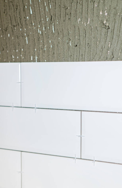 Montaje de azulejos blancos en el delantal de cocina
. - Foto, Imagen