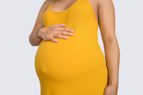 Close-up of pregnant woman touching her big belly. Pregnancy, motherhood and expectation concept. - Photo, image