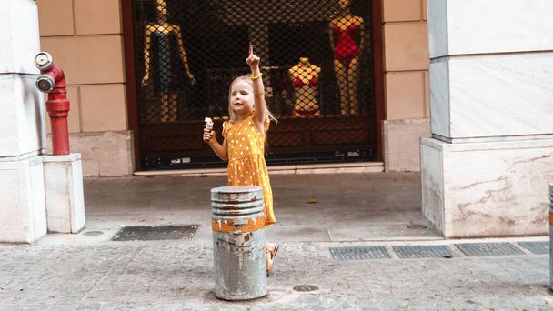little girl eating ice cream in the street  - Fotoğraf, Görsel