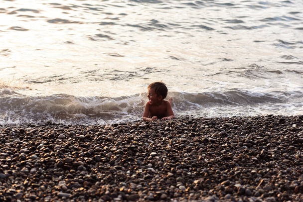 little boy playing with sand on the beach - Fotó, kép